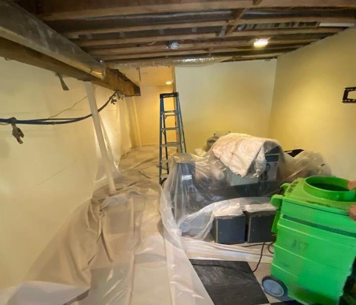Basement with commercial mold damage and plastic barriers with SERVPRO equipment