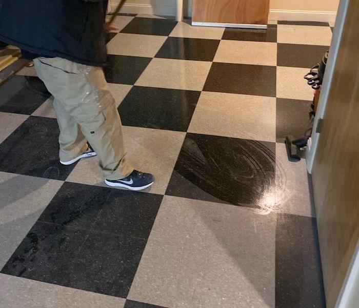 SERVPRO technician mopping a black and white floor