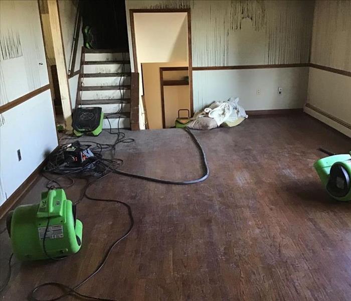 Room with hardwood floors and SERVPRO drying equipment
