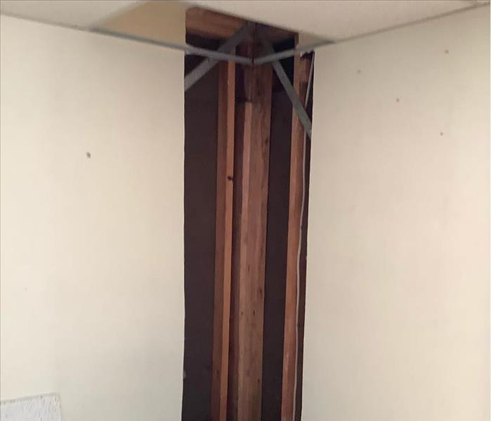 Room with a ceiling tile and sheetrock sheet removed