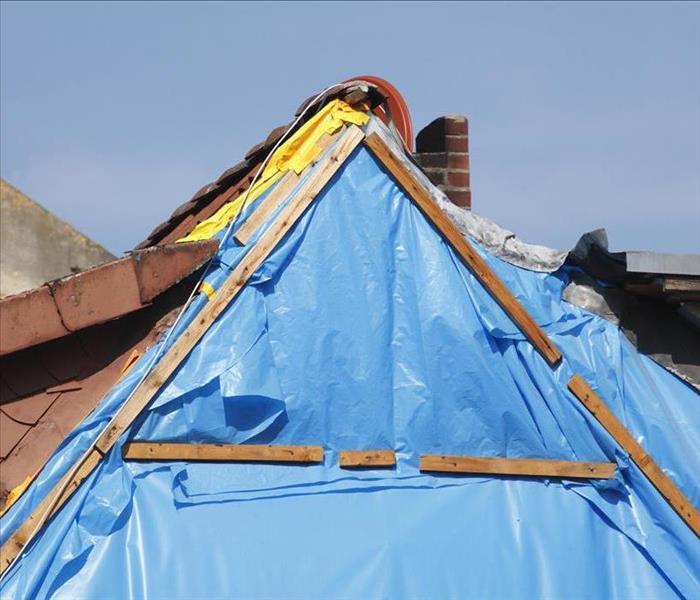 blue tarp on gable of roof